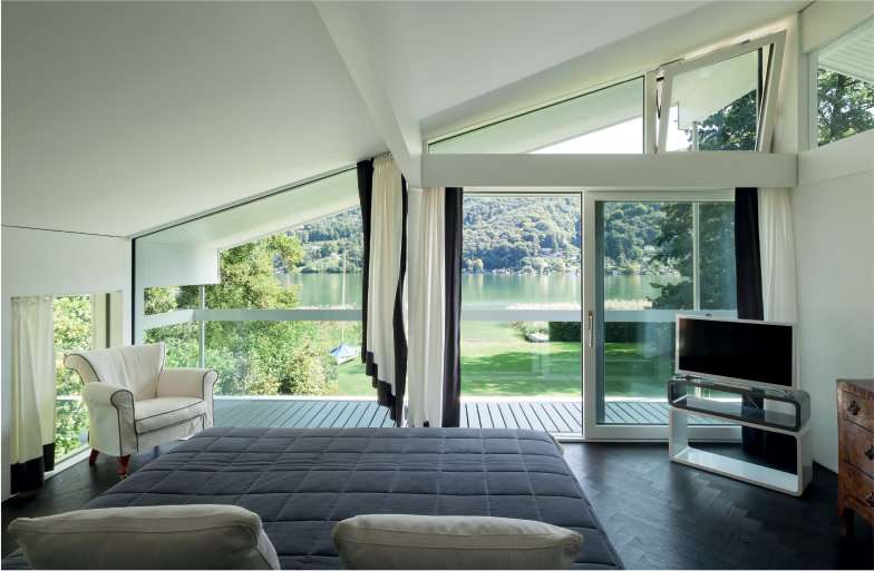 A bright bedroom with a white patio door and big architectural window